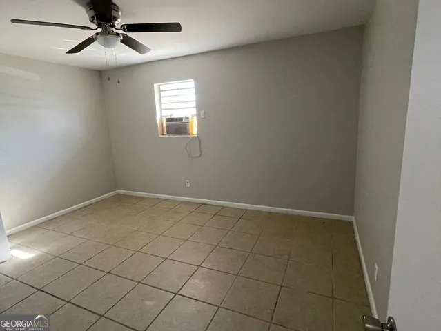 an empty room with windows and fan