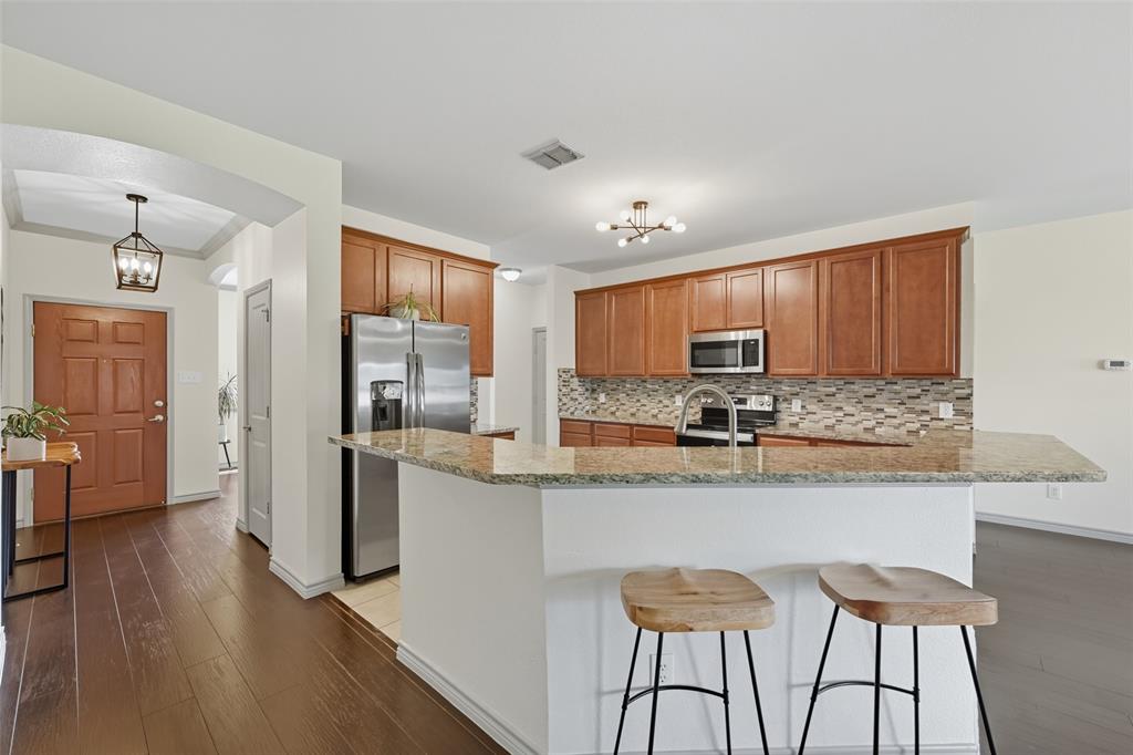 308 Sheridan Road Oak Point, TX 75068 - Photo 8 of 20 a kitchen with stainless steel appliances granite countertop a refrigerator a sink dishwasher a stove and white cabinets with wooden floor
