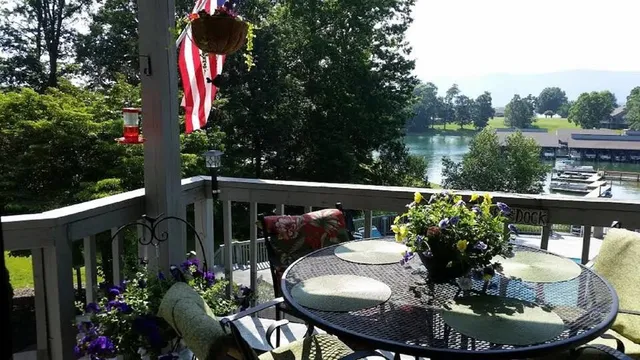 a balcony with wooden floor table and chairs