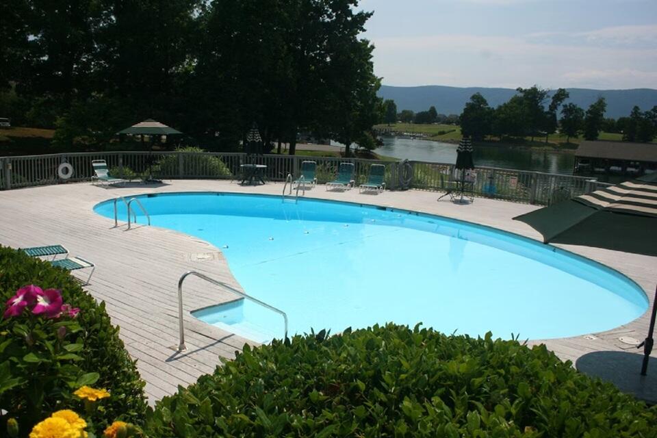 290 Sailors Cove Drive, Unit 405 Moneta, VA 24121 - Photo 16 of 22 a view of a swimming pool with a bench and trees around