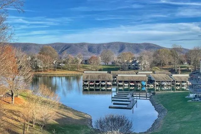a blue swimming pool is sitting next to a lake