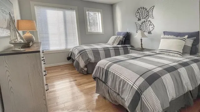 a bedroom with two beds and painting on the wall