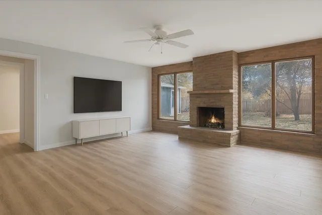 a view of an empty room with a fireplace and a window