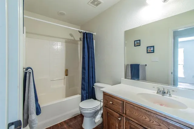 a bathroom with a sink a toilet a mirror and shower