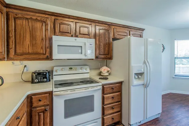 a kitchen with stainless steel appliances granite countertop a refrigerator and a stove top oven