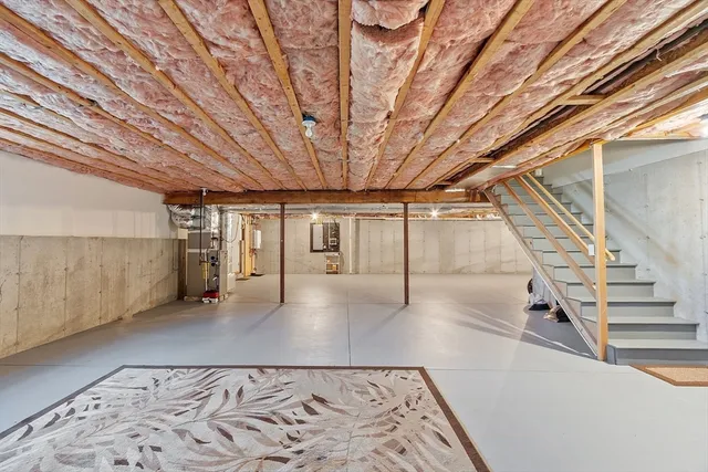 a view of an empty room with wooden floor and stairs
