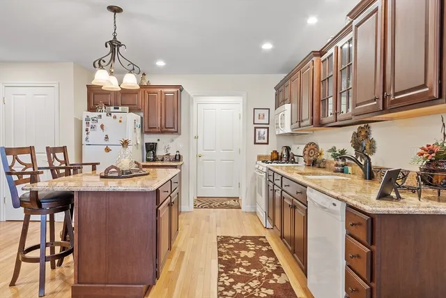 a kitchen with granite countertop a sink stove and cabinets