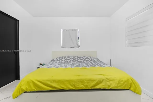 a bed sitting in a bedroom next to a window