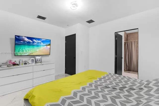 a bedroom with a bed and a flat screen tv