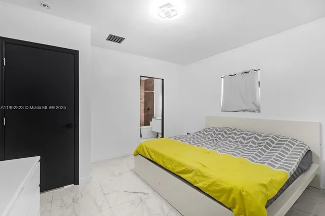 a bedroom with a bed and dresser with mirror