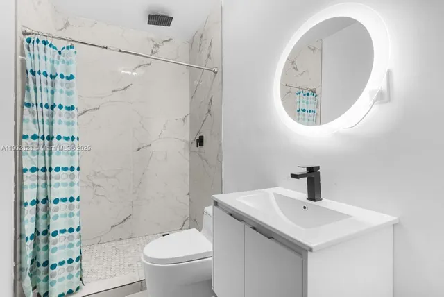 a bathroom with a toilet a sink and a mirror