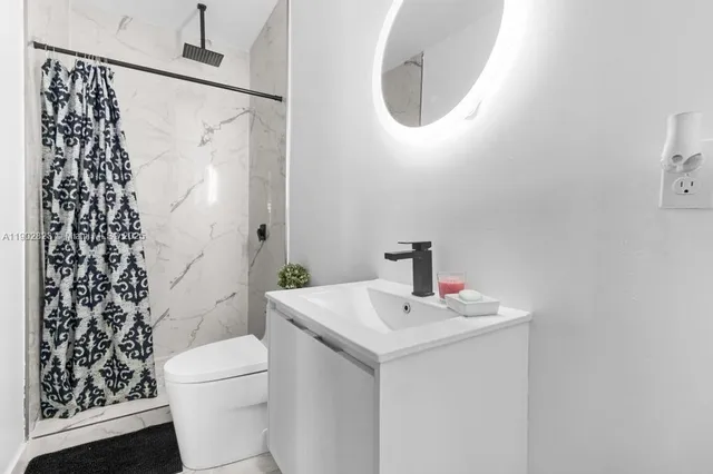a bathroom with a sink mirror and toilet
