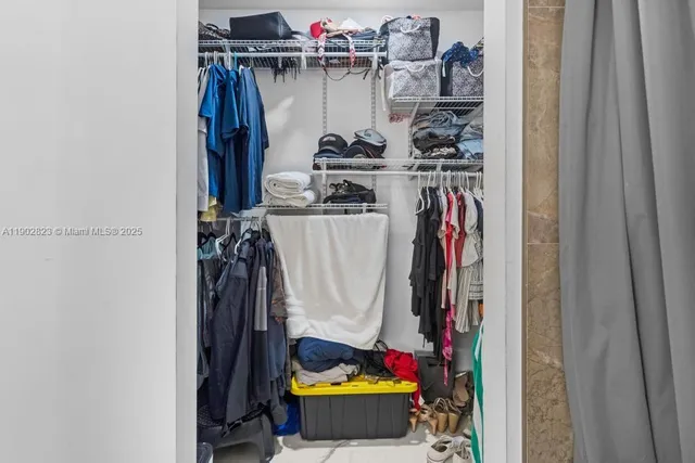 a view of walk in closet with clothes and shoes
