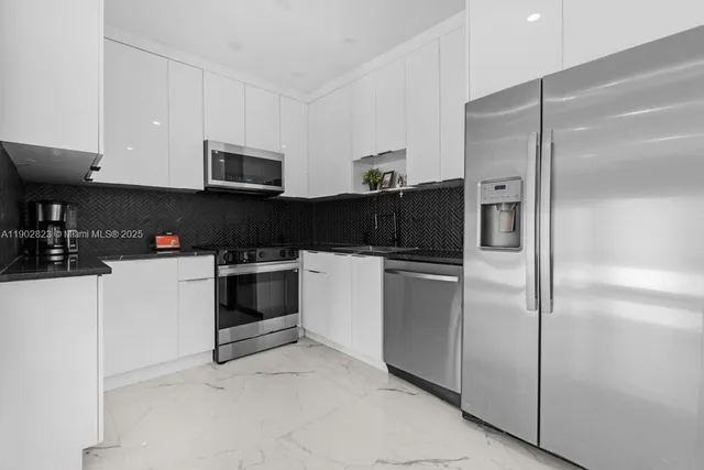 a kitchen with a refrigerator stove and white cabinets