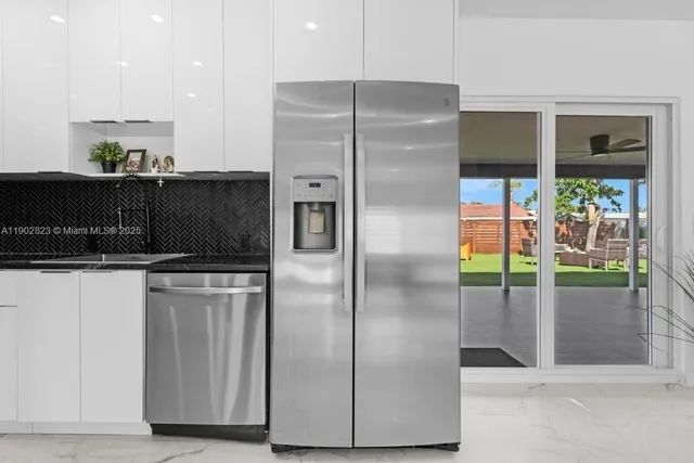 a kitchen with stainless steel appliances granite countertop a refrigerator and a sink