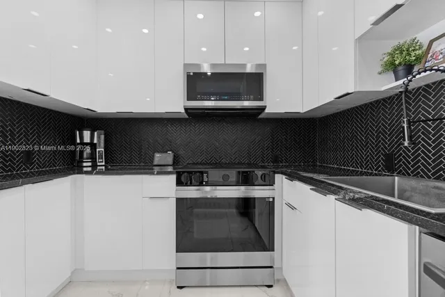 a kitchen with granite countertop a stove and a sink
