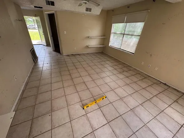 en empty room with windows and chandelier