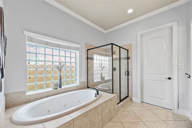a spacious bathroom with a granite countertop double vanity sink a mirror and a bathtub