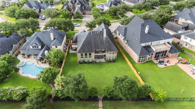 an aerial view of a house with swimming pool big yard and a fountain