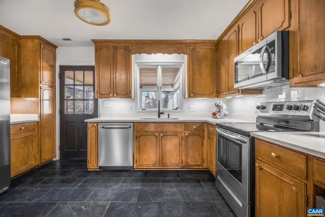 a dining room with furniture large windows and wooden floor