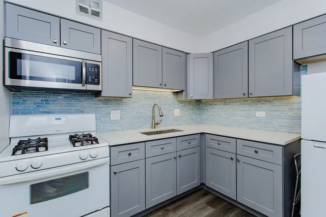 a kitchen with white cabinets stainless steel appliances and sink
