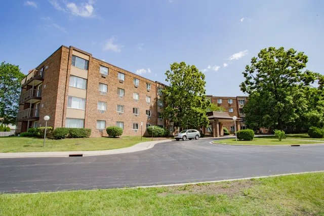 a front view of a building with trees