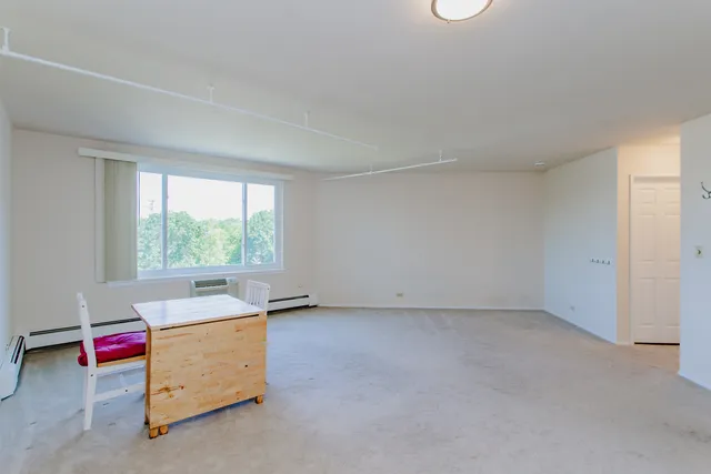 an empty room with a window and couch