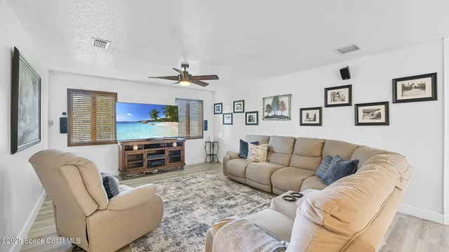 a living room with furniture a large window and a flat screen tv