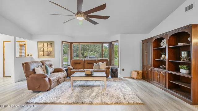 a living room with furniture and two large window