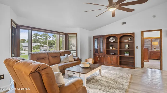 a dining room with furniture a chandelier and wooden floor