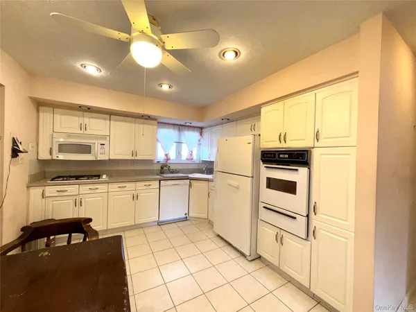 a kitchen with a refrigerator and white cabinets