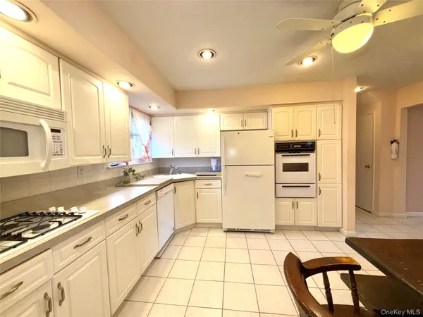 a kitchen with granite countertop a refrigerator and a stove top oven