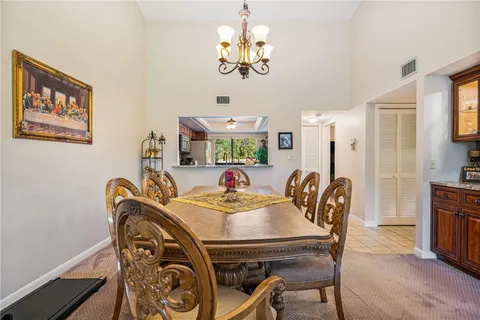 a view of a dining room with furniture a chandelier and wooden floor
