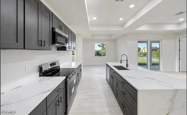a kitchen with stainless steel appliances a sink stove and cabinets