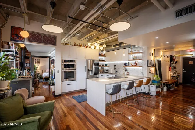 a view of a dining room with furniture a chandelier and wooden floor