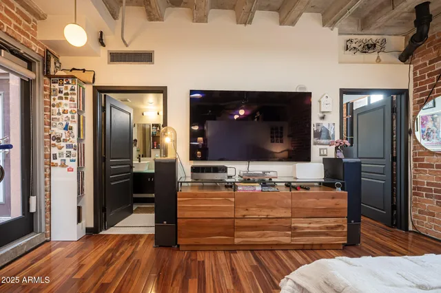 a view of a patio with couches table and chairs under an umbrella with a fireplace