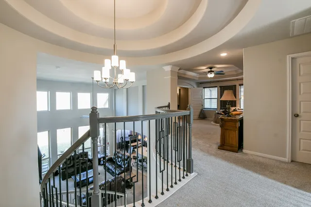 a view of a hallway with dining room and chandelier