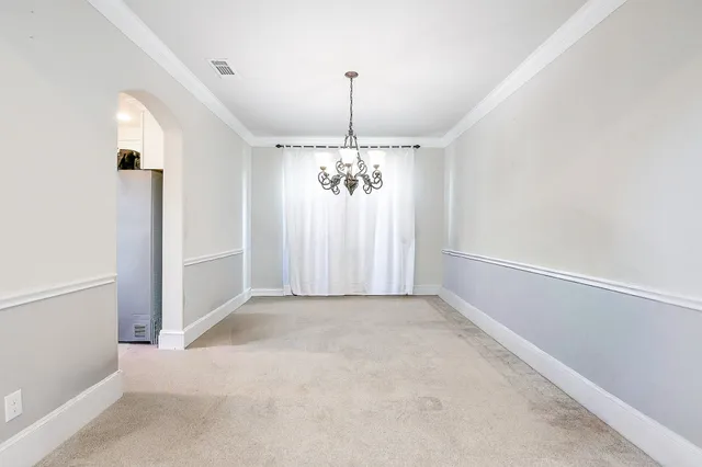 an empty room with windows and chandelier