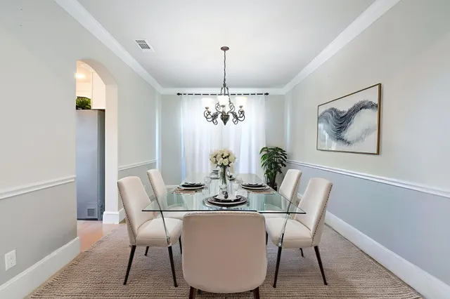 a dining room with furniture potted plants and wooden floor