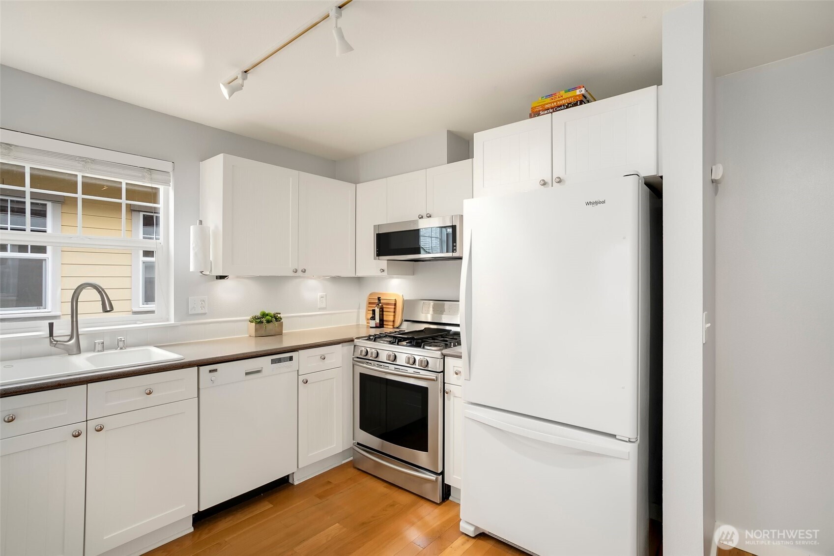 5430 California Avenue Southwest, Unit 3A Seattle, WA 98136 - Photo 11 of 32 a kitchen with granite countertop white cabinets and white appliances