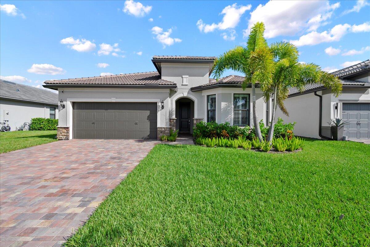 a front view of a house with a garden and yard