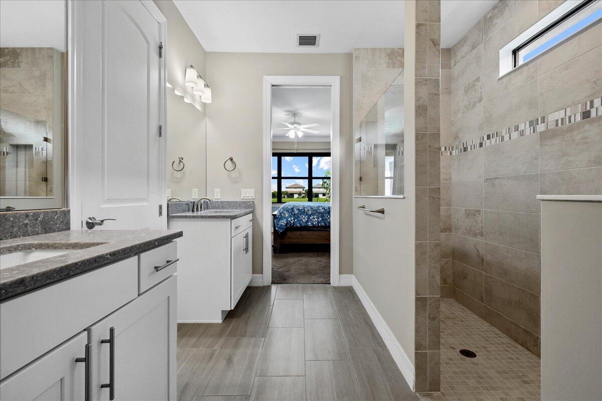 8311 Pedigree Circle Lake Worth, FL 33467 - Photo 13 of 37 a bathroom with a double vanity sink and mirror
