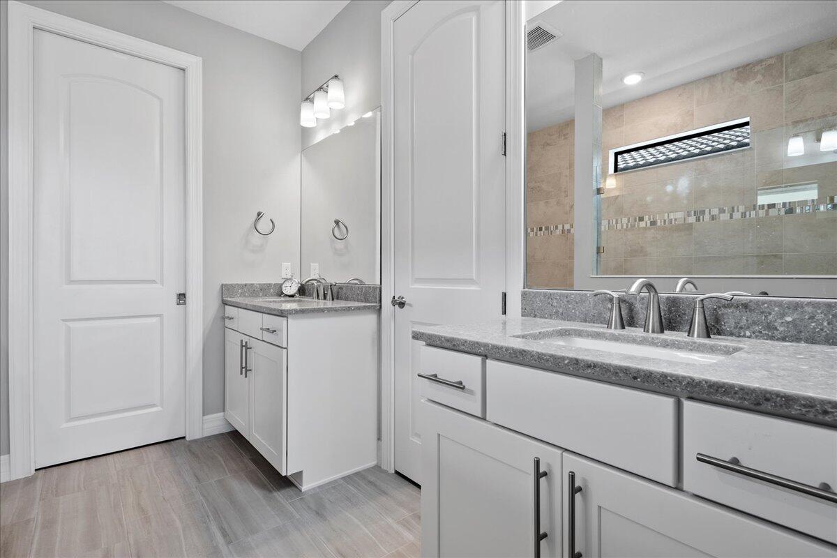 8311 Pedigree Circle Lake Worth, FL 33467 - Photo 14 of 37 a bathroom with a double vanity sink and mirror