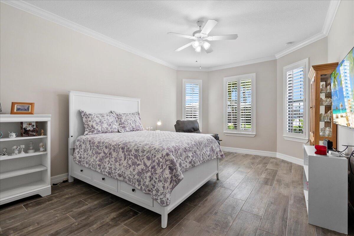 8311 Pedigree Circle Lake Worth, FL 33467 - Photo 15 of 37 a bedroom with a large bed and a chandelier