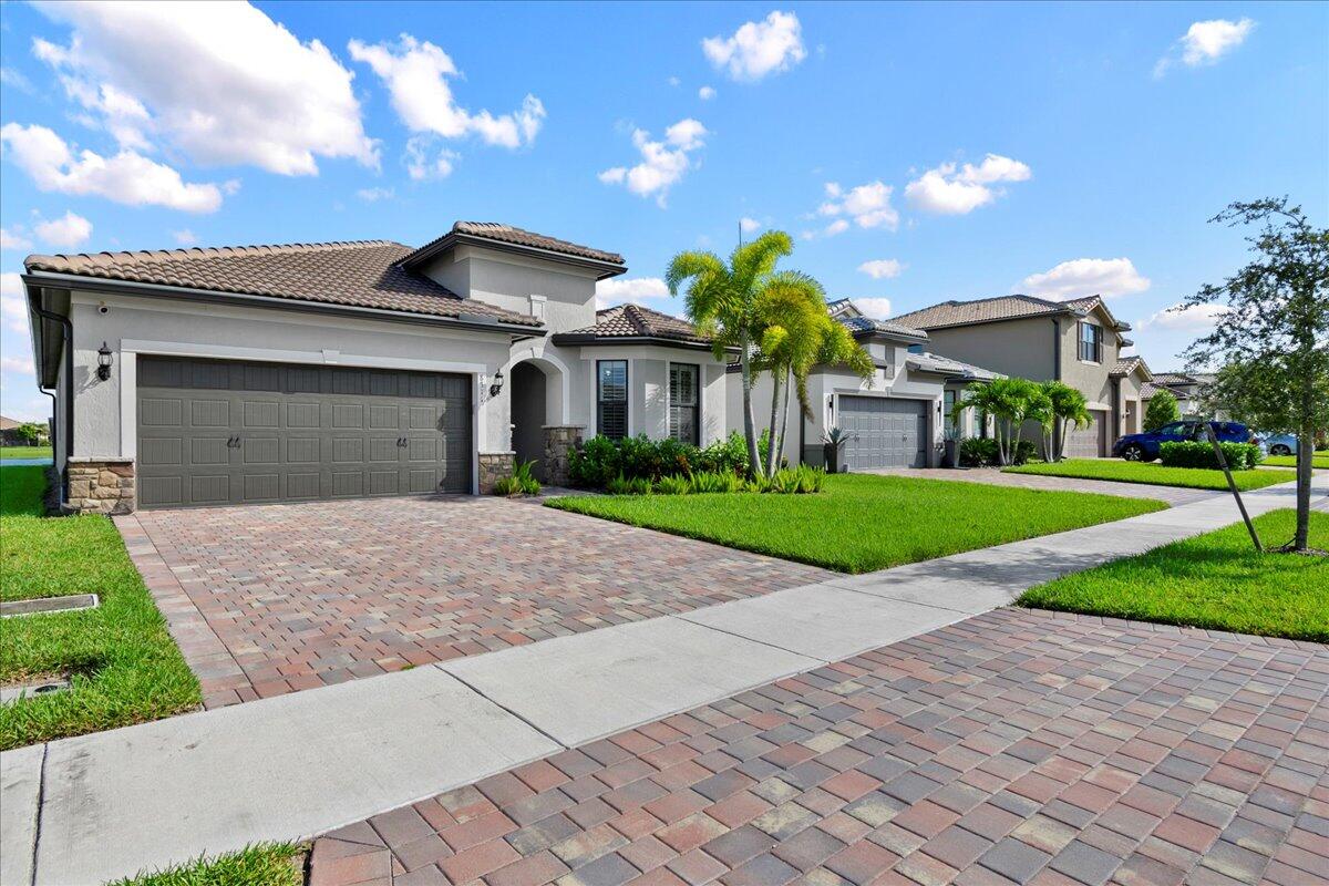 8311 Pedigree Circle Lake Worth, FL 33467 - Photo 2 of 37 a view of a white house with a yard and plants