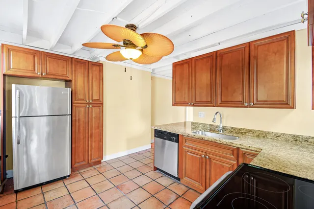 a kitchen with stainless steel appliances granite countertop a sink refrigerator and cabinets
