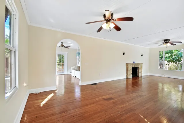 a view of a livingroom with wooden floor and a ceiling fan