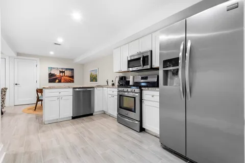 a kitchen with stainless steel appliances a refrigerator sink and cabinets