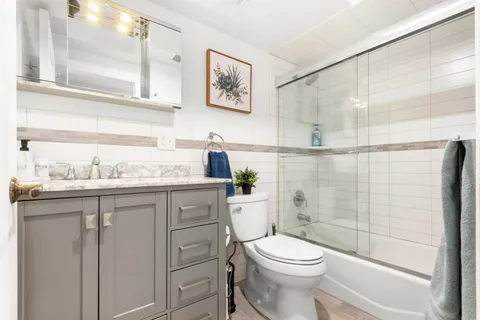 a bathroom with a granite countertop sink toilet and shower