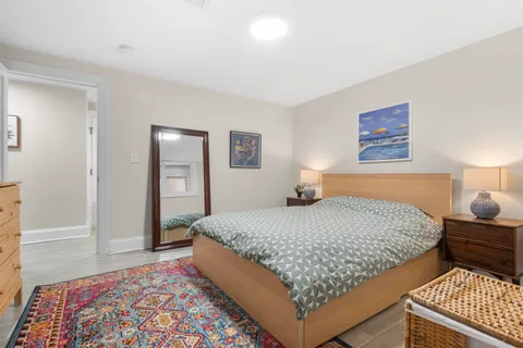 a bedroom with wooden floor and a rug